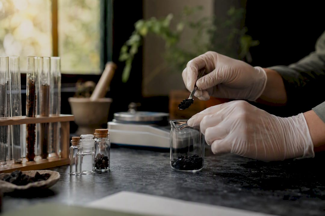 Laboratory bench with hands handling shilajit test samples