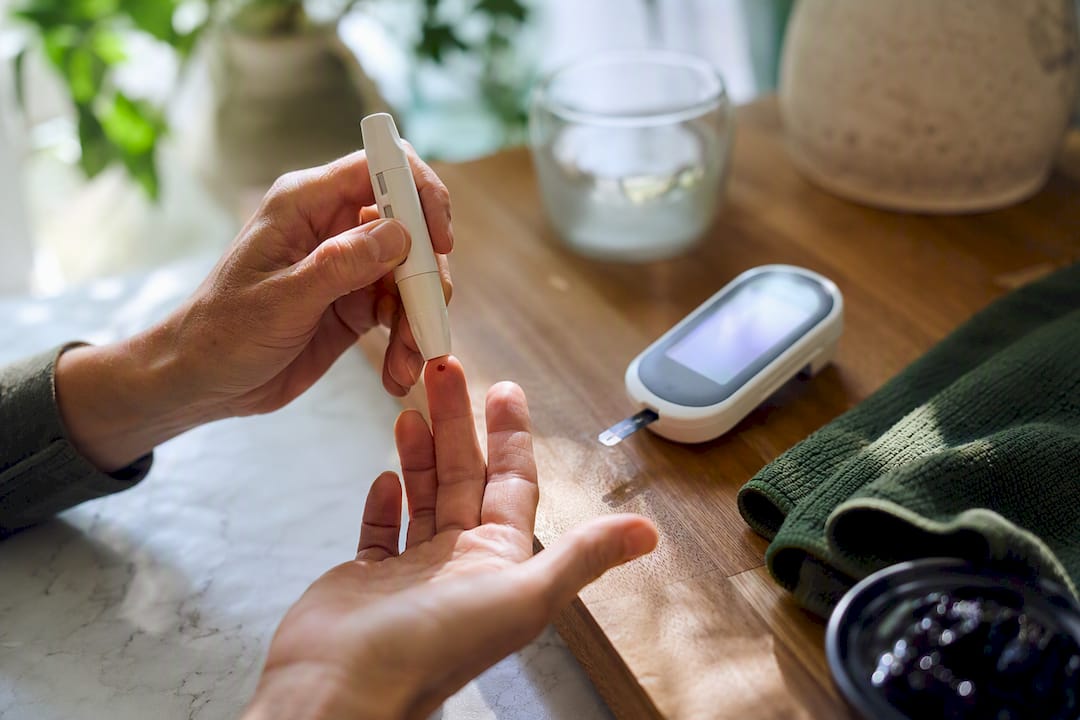 Hand checking blood glucose beside shilajit resin